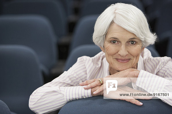 Senior Caucasian woman smiling in lecture hall