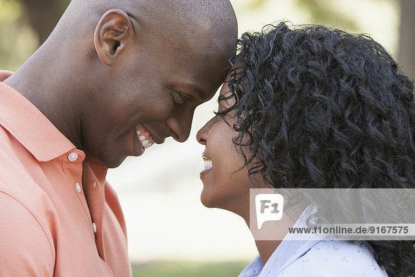 Couple touching foreheads outdoors