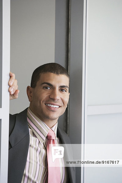 Hispanic businessman standing in doorway