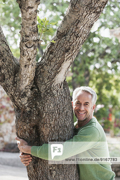 Man hugging tree outdoors