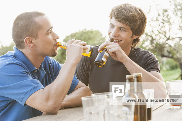 Men drinking beer together outdoors