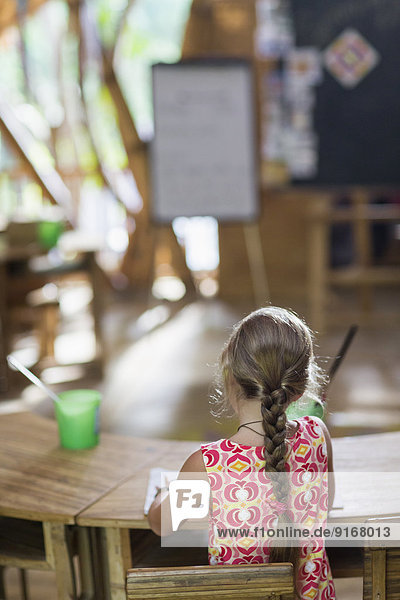 Caucasian girl painting at desk