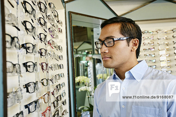 Filipino man trying on glasses at optometrist