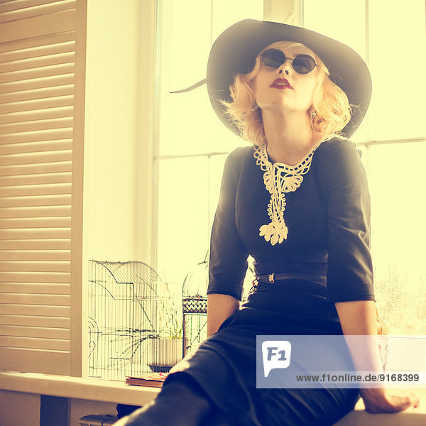 Caucasian woman wearing sunglasses and hat indoors