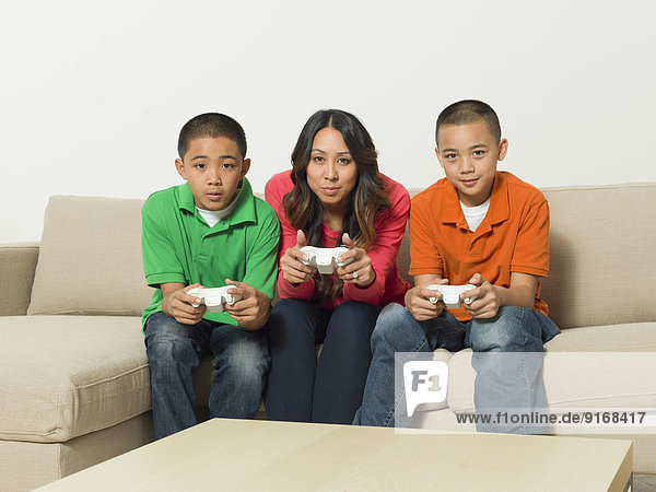 Mother and sons playing video games together