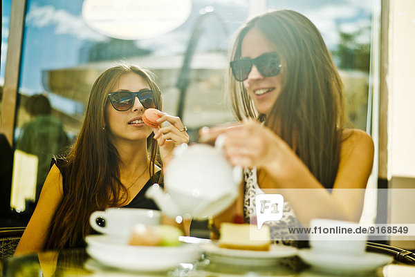 Women having coffee together at sidewalk cafe