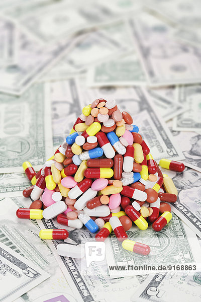 Pile of prescription pills on dollar bills