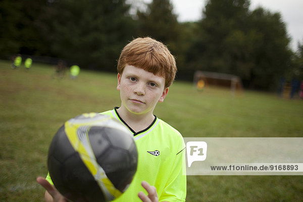 Caucasian boy playing soccer on field