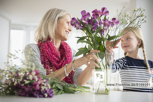 Senior Caucasian woman and granddaughter arranging flowers