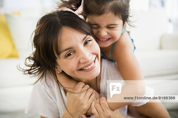 Hispanic mother and daughter playing in living room