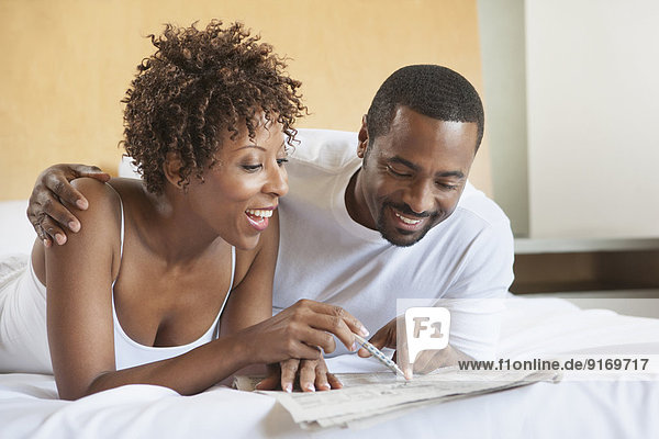African American couple reading in bed