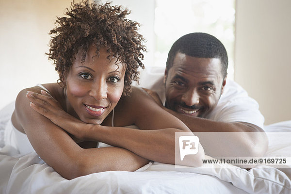 African American couple relaxing in bed