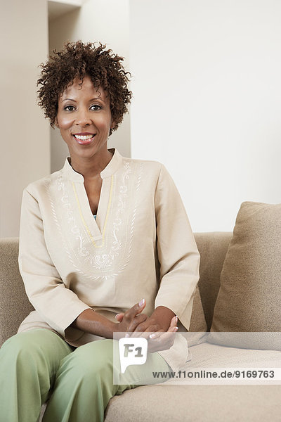 African American woman sitting on sofa