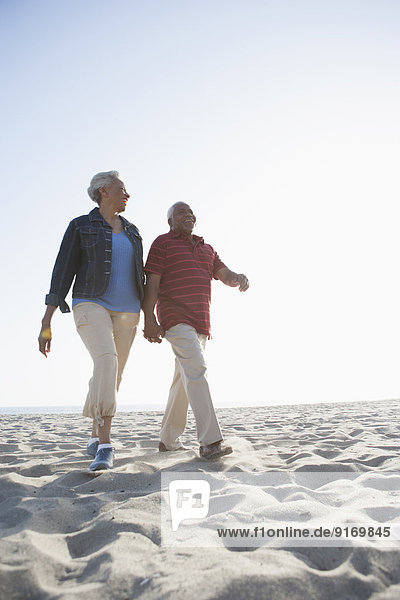 Senior African American couple walking on beach