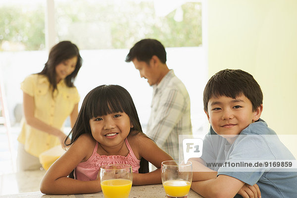 Children drinking orange juice at breakfast