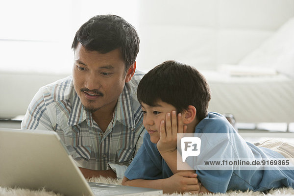 Father and son using laptop together