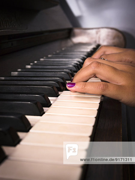 Junge Frau beim Klavierspielen  Teilansicht