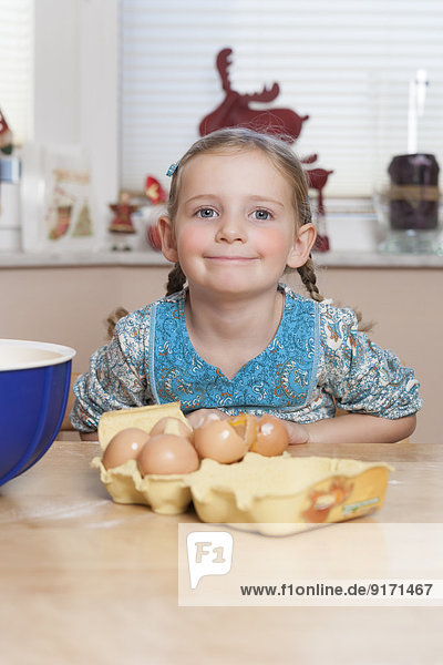 Porträt des kleinen Mädchens am Küchentisch sitzend