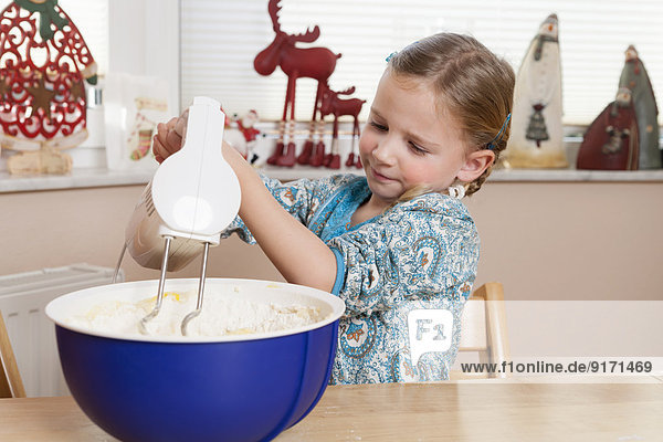 Porträt eines kleinen Mädchens beim Rühren von Teig mit Mixer