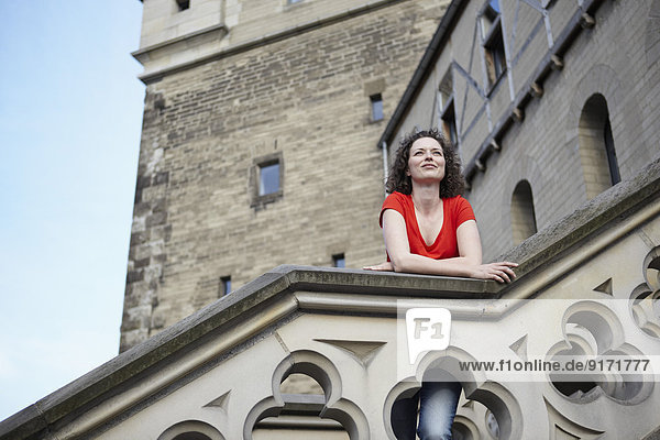 Deutschland  Nordrhein-Westfalen  Köln  Frau auf Geländer eines alten Turmes gestützt