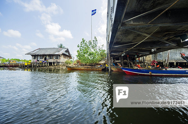 Indonesien  Riau Inseln  Bintan Insel  Fischerdorf  Brücke  Fischerhütte und Flagge