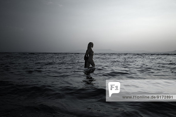 Griechenland  Korfu  nackte junge Frau  die im Meer spazieren geht