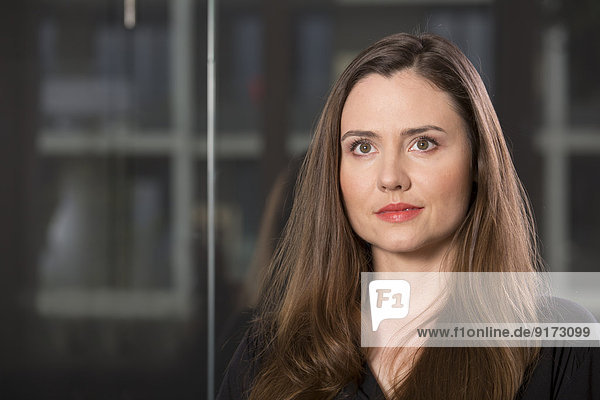 Portrait der Geschäftsfrau vor der Glasscheibe