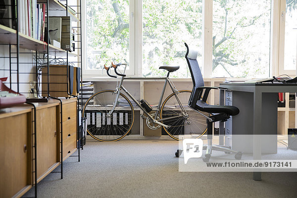 Racing cycle standing at workplace of modern office