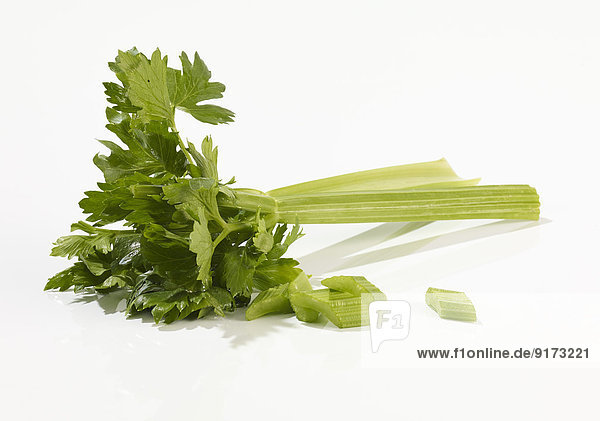 Two celery stalks and parts in front of white background