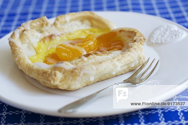Danish pastry  a viennoiserie pastry with puff pastry  soy pudding and mandarins
