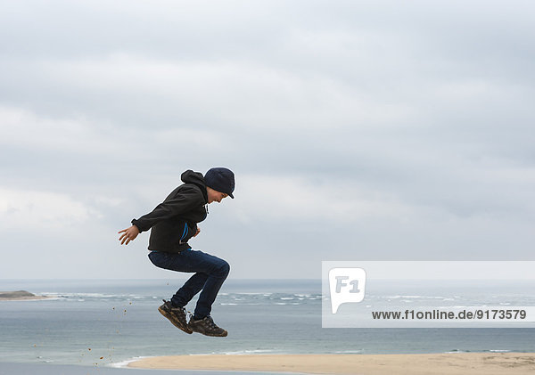 France  Aquitaine  Gironde  Pyla sur Mer  Dune du Pilat  jumping boy on sand dune