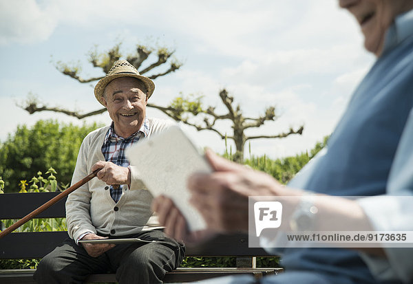Deutschland  Worms  Zwei alte Männer mit Tablet-Computern im Park