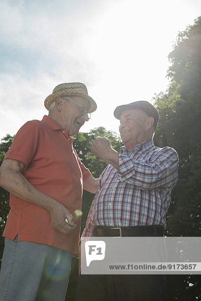 Zwei alte Freunde mit Boulebällen im Park