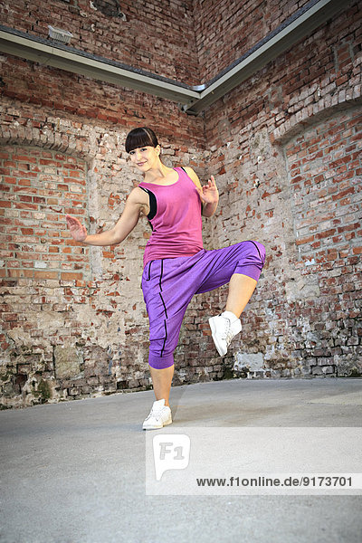 Frau im Sportkleid tanzt zumba oder Aerobic im Fitnessstudio