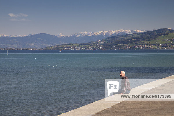 Switzerland  Thurgau  Arbon  One senior man sitting at lakeside promenade