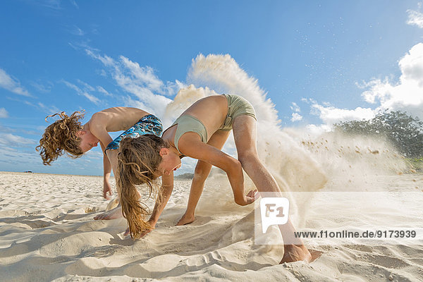 Australia  New South Wales  Pottsville  boy and girl digging in sand on beach