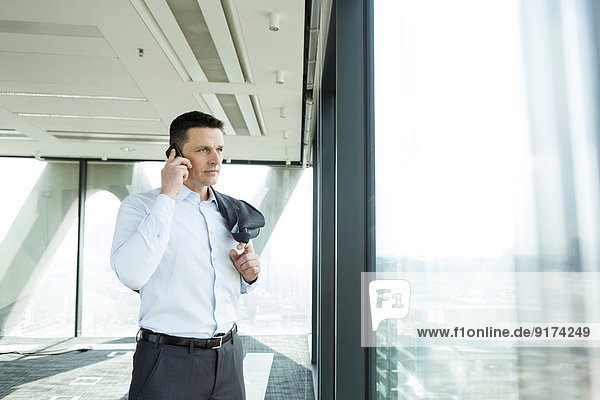 Businessman in office on cell phone
