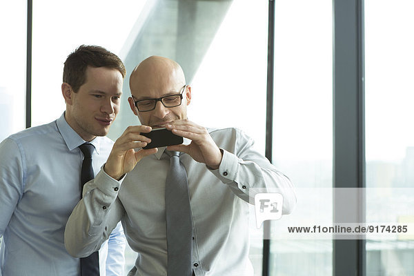 Zwei Geschäftsleute schauen auf das Handy