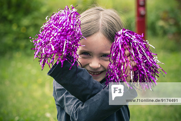 Porträt eines glücklichen kleinen Mädchens beim Spielen mit Dekorationsmaterial