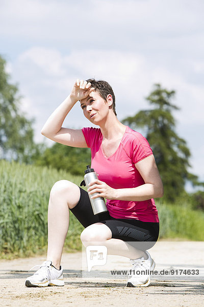 Female jogger relaxing after running