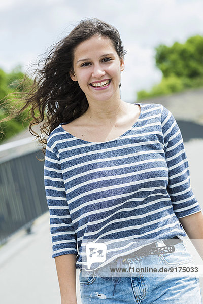Porträt einer lächelnden jungen Frau mit wehendem Haar