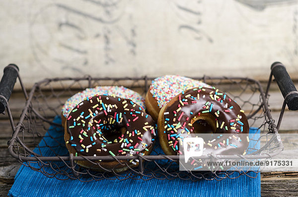 Korbdraht mit vier mit Zuckergranulat verzierten Donuts