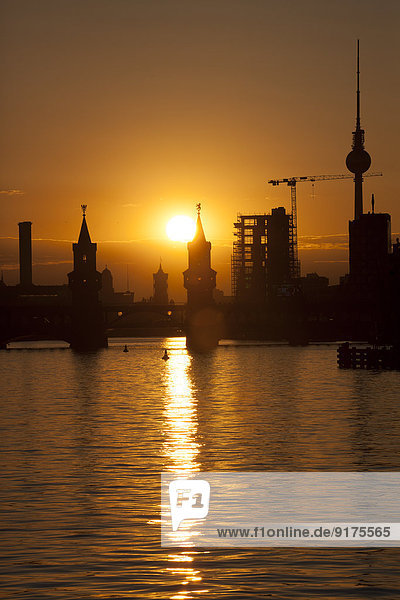 Deutschland,  Berlin,  Friedrichshain-Kreuzberg,  Oberbaumbrücke und Spree,  Berliner Fernsehturm im Hintergrund,  bei Sonnenuntergang