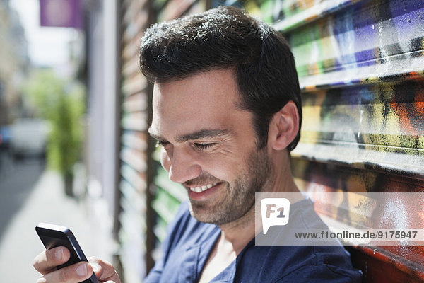 France Paris portrait of smiling man using his smartphone