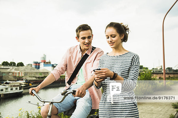 Junges Paar mit Fahrrad und Smartphone