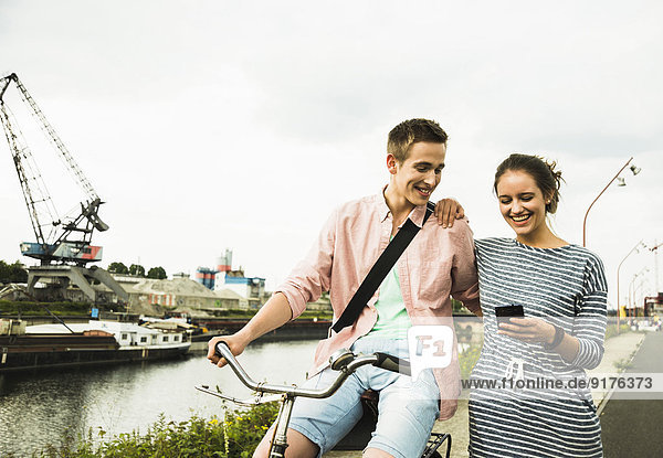 Young couple with bicycle and smartphone