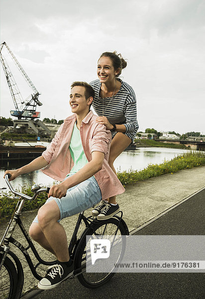 Young couple driving together on bicycle