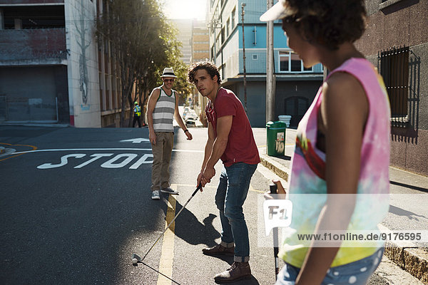 Friends playing urban golf in the city