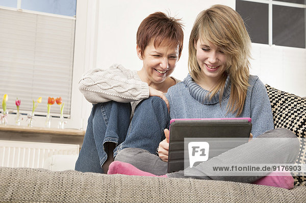 Germany  Berlin  Mother and daughter using digital tablet