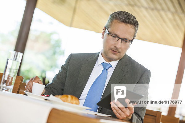 Geschäftsmann im Restaurant mit digitalem Tablett